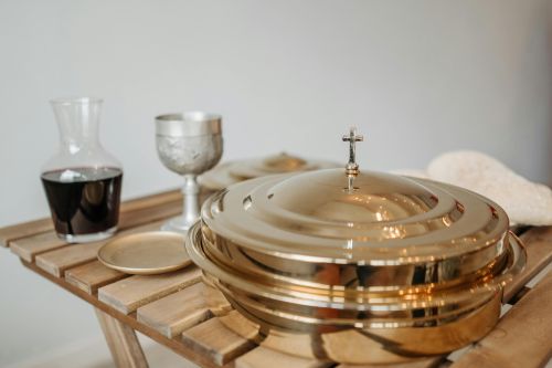 Chalice, communion tray, and wine setup for religious ceremony.